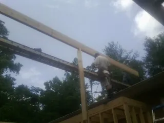 Carpenter setting a ridge beam over a new addition frame — Ice Dam Removal by Roofing Brothers in Tennessee