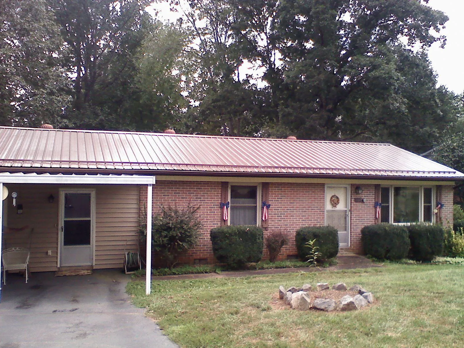 Bronze metal roof and carport on a brick ranch home — Roof Repair work by our crew in Tennessee